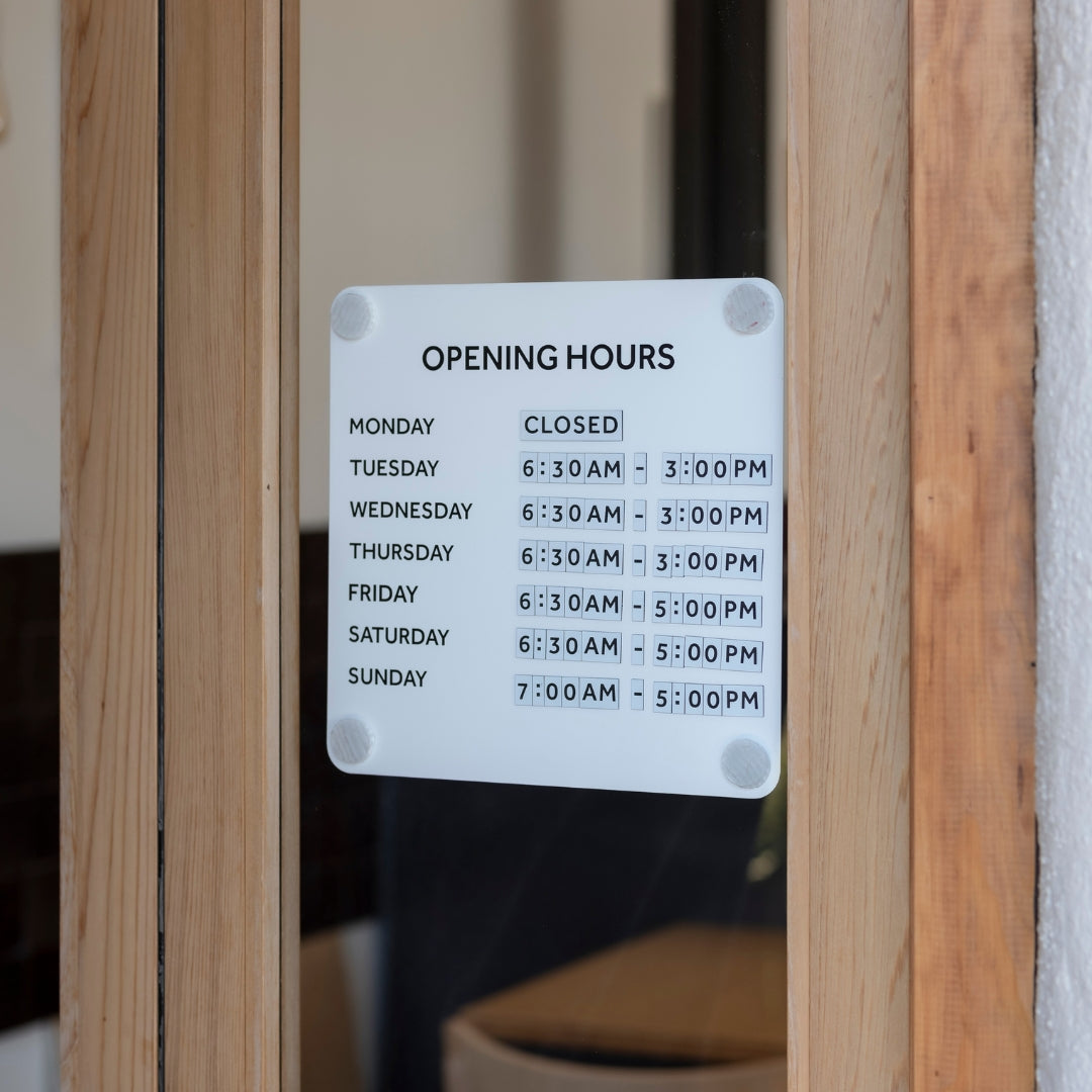 Shop hours sign on front door glass