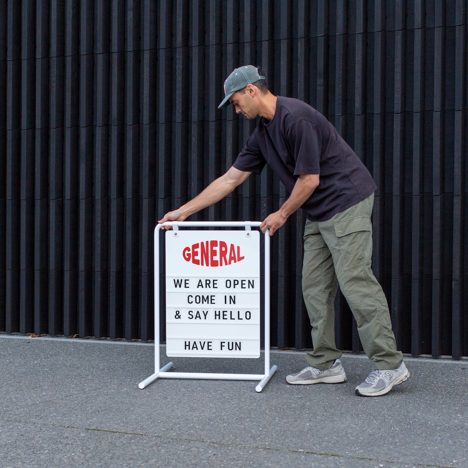 person with outside white swing letter sign with customised branding